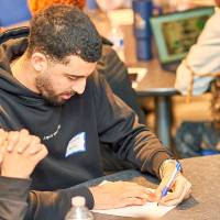 International Anchor Allies Winter 2026 First Mixer - a student cross checking his bingo marks